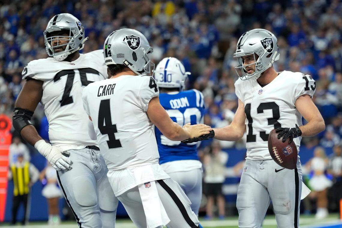 Las Vegas Raiders wide receiver Hunter Renfrow celebrates with teammate quarterback Derek Carr after catching an 11-yard touchdown pass during the second half of an NFL game against the Indianapolis Colts, Sunday, Jan. 2, 2022, in Indianapolis.