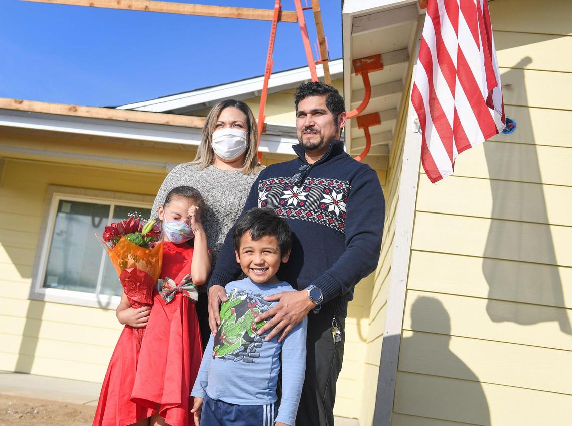Members of the Delgado family stand outside what will be their new home after being announced as the recipients of the newest Habitat for Humanity build in Clovis on Wednesday, Dec. 8, 2021.
