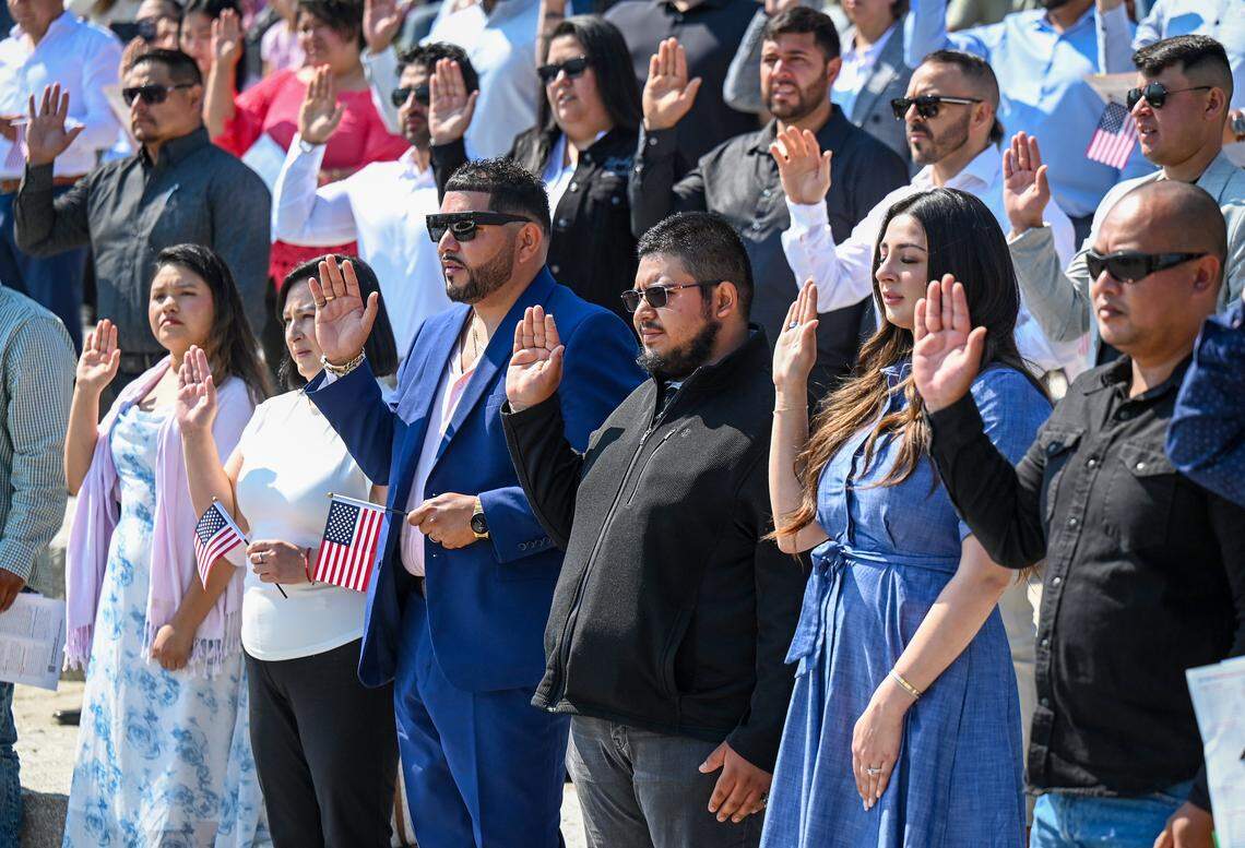 Citizen candidates raise their hands to take the Oath of Allegiance during a naturalization ceremony held at Glacier Point in Yosemite National Park to commemorate Constitution Day and Citizenship Day on Wednesday, Sept. 17, 2025.