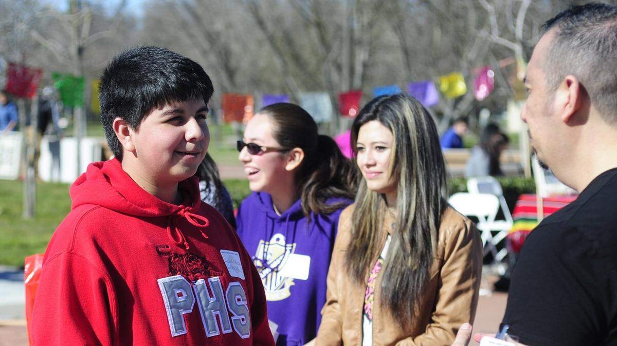 Nickolas Murillo, 15, from Patterson High School, talks about entrepreneurship and starting a business at an information table, at California State University, Stanislaus, in Turlock, during a previous Chicano Latino Youth Conference. Such events have been put off because of the coronavirus pandemic.