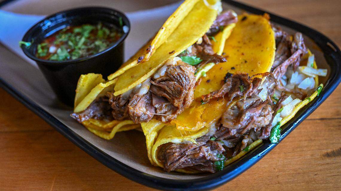 A pair of birria tacos with cheese and consome are served up at Mex Sabor Cocina Mexicana, a New Mexican restaurant in Fresno’s River Park shopping center.
