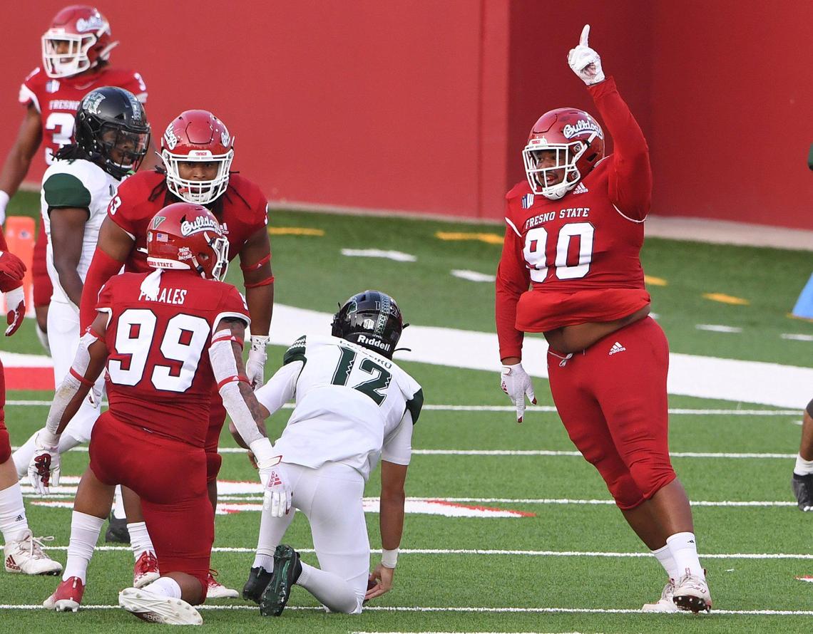 Fresno State’s Kevin Atkins, right, celebrates sacking Hawai’i’ quarterback Chevan Cordeiro, center, Saturday, Oct. 24, 2020 in Fresno. The first quarter ended tied 7-7.