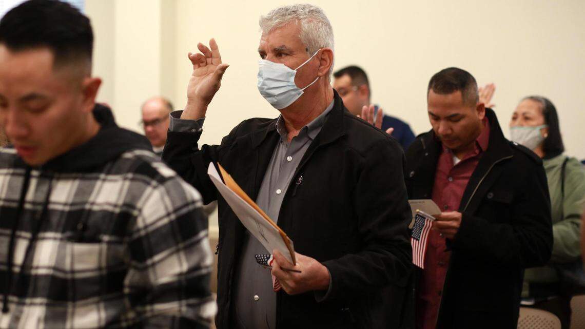 Cirilo Loera Pinedo, de Jalisco, México, (centro) toma juramento a la bandera de los Estados Unidos durante una ceremonia de naturalización el martes, 24 de enero en las oficinas del Servicios de Inmigración y Ciudadanía de los Estados Unidos en Fresno.