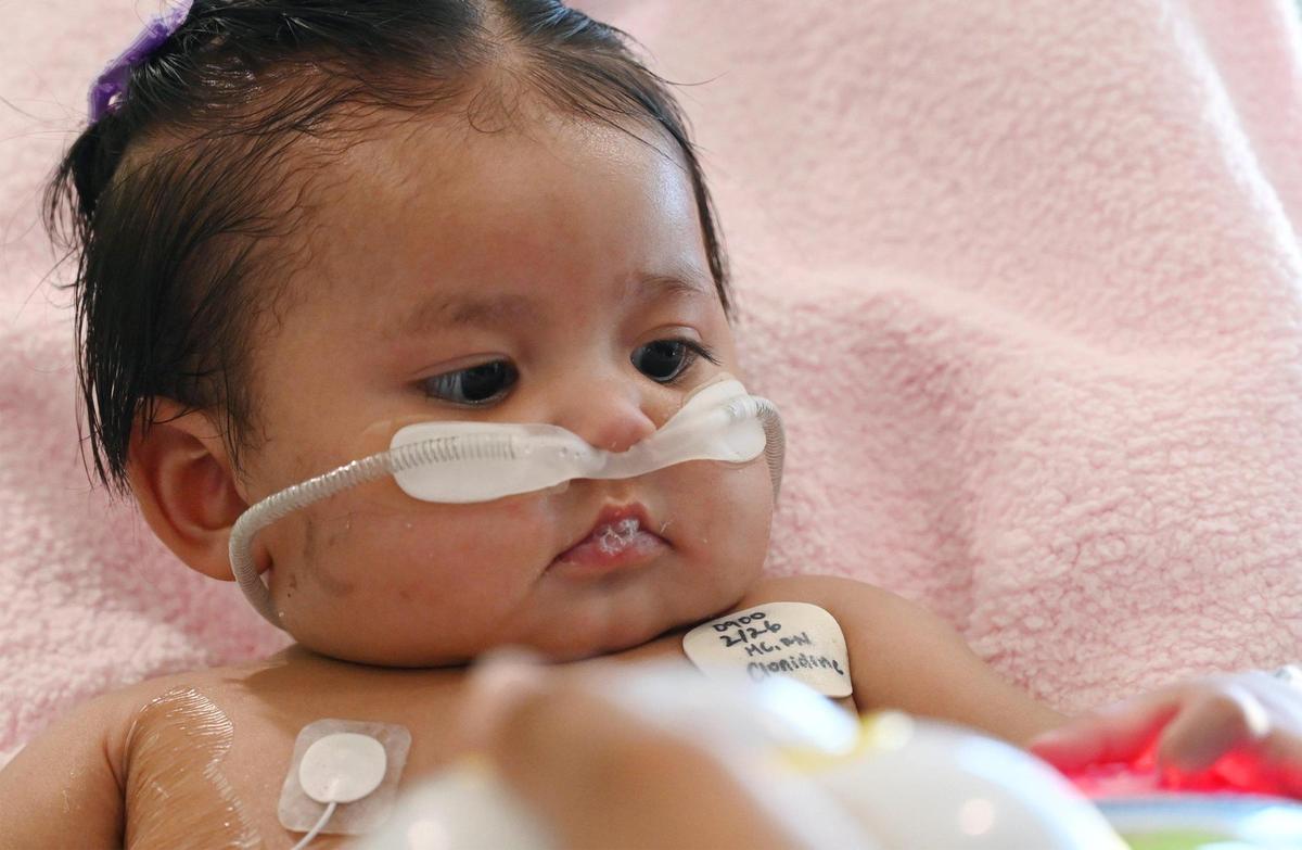 Victoria Saypen plays with a battery-operated toy as she recovers from respiratory syncytial virus, or RSV, at Valley Children’s Hospital’s ICU. A breathing tube was used for a few weeks and she developed complications from a small bowel perforation, but she is doing well and was expected to be released within days. Photographed at Valley Children’s Hospital, Thursday, March 2, 2023 in Madera County.