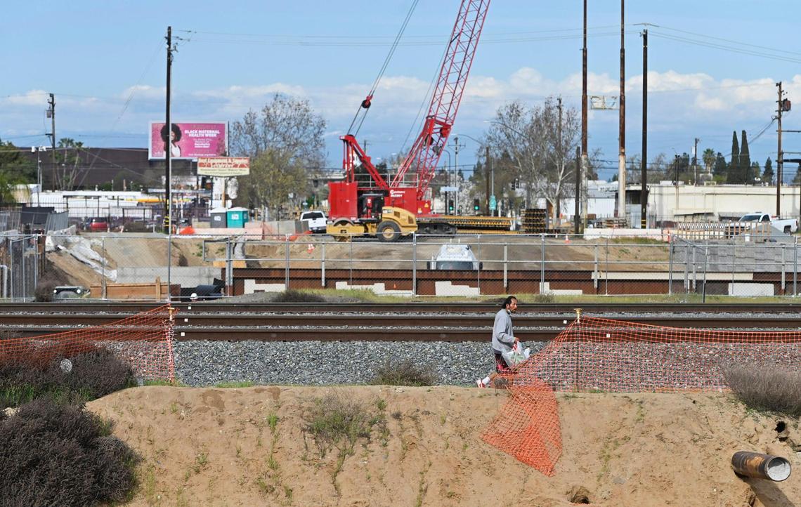 A man walks through the construction zone for a high-speed rail underpass in downtown Fresno in 2024. 