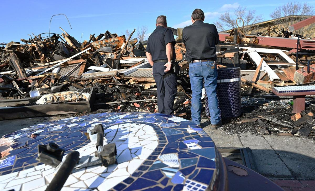 Two men stand surveying the damage after Valley Crime Stoppers President Dale Mendoza announced an increase of a reward to $5,000 for information about the fire that consumed several businesses in a strip mall near Kings Canyon and Clovis avenues during a press conference at the site Wednesday, Jan. 18, 2023 in Fresno.