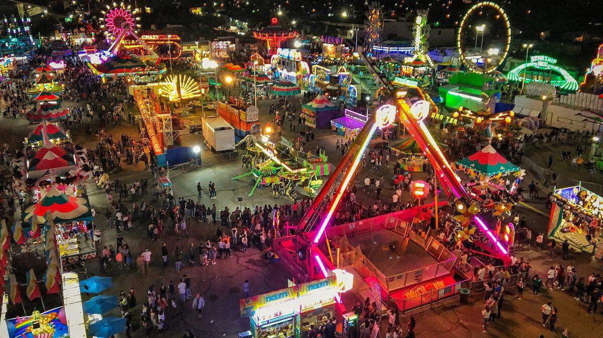FILE - Carnival rides are lit up at night as seen from the big Ferris Wheel from Butler Amusements at the Big Fresno Fair on Oct. 6, 2018.