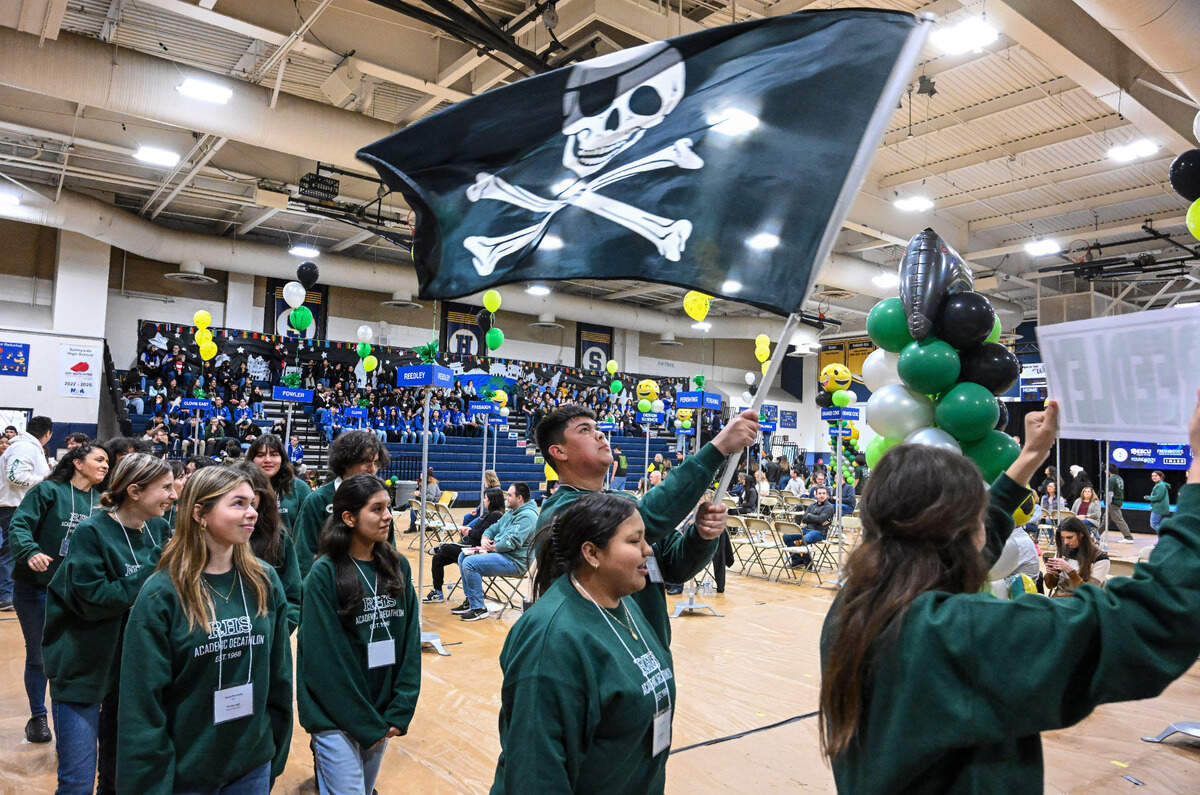 Members of the Reedley Pirates Academic Decathlon team enter the gymnasium at Sunnyside High School waving a skull and crossbones flag before the start of the Super Quiz portion of the 42nd annual Fresno County Academic Decathlon on Saturday, Feb. 3 2024.
