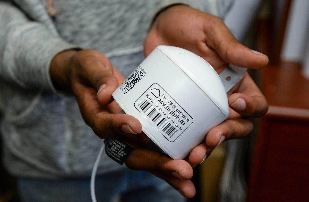 Kieshaun White, an 18-year-old who grew up in SW Fresno and has been detailing differences in air quality between north and south Fresno, holds up an air quality monitor he is installing at Phoenix High School in Fresno on Tuesday, Dec. 11,2 018. White is working to install air quality monitors at high schools throughout Fresno Unified School District and developing an app so people can check air quality in real time on those school campuses.