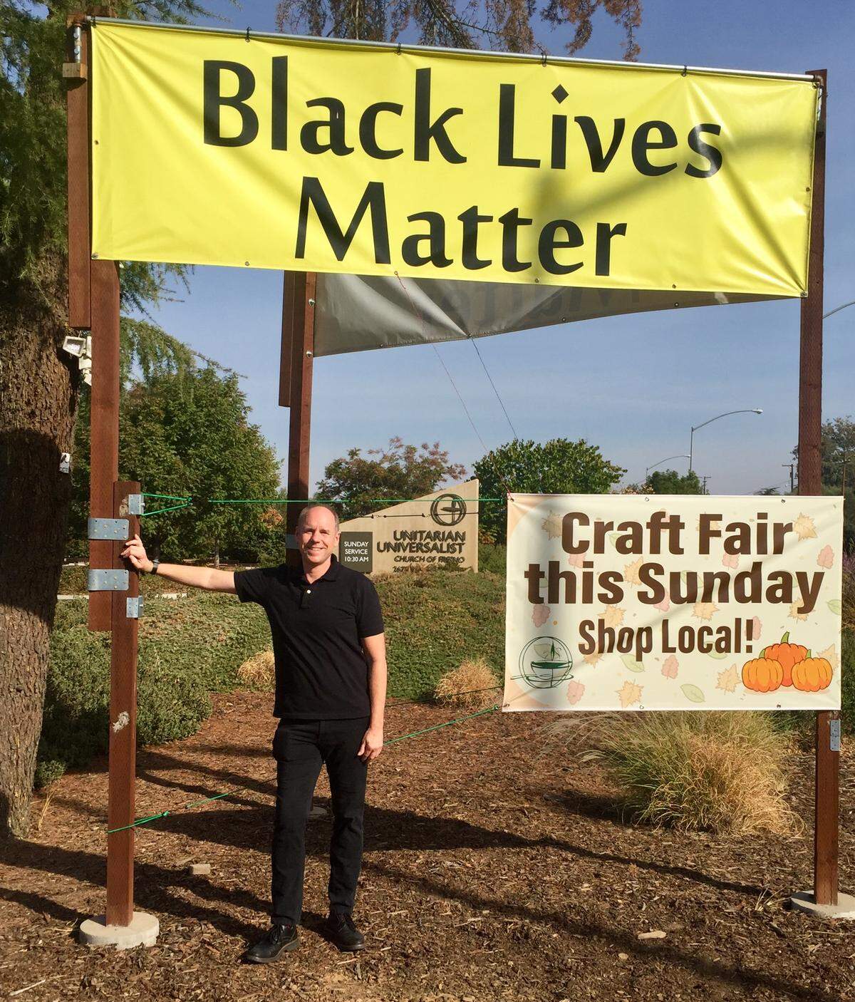 Rev. Tim Kutzmark beside Black Lives Matter signs outside the Unitarian Universalist Church of Fresno.