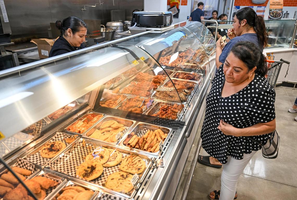 Shoppers check out the hot food offerings in the Pepe’s Kitchen area of the new El Super supermarket on the north end of Manchester Center in Fresno on Wednesday, June 25, 2025.