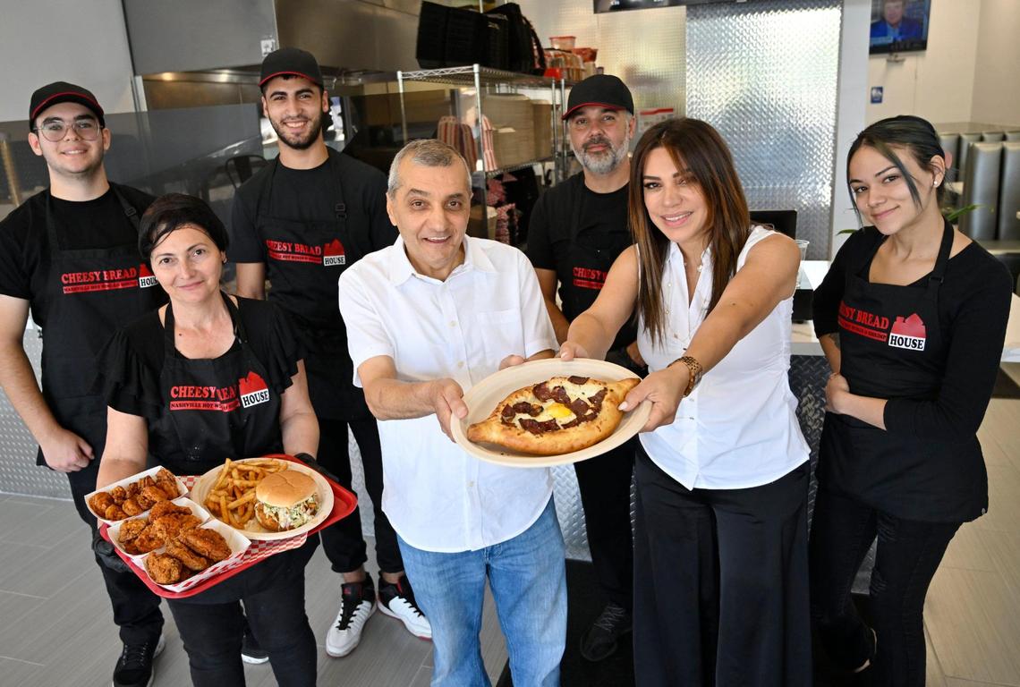 Arut Mkhitaryan, center left, stands next to branch manager Karine Sahakyan, center right, surrounded by staff and samples of their food from Cheesy Bread House, located in the Costco shopping center on West Shaw Avenue. Photographed Friday, June 23, 2023.