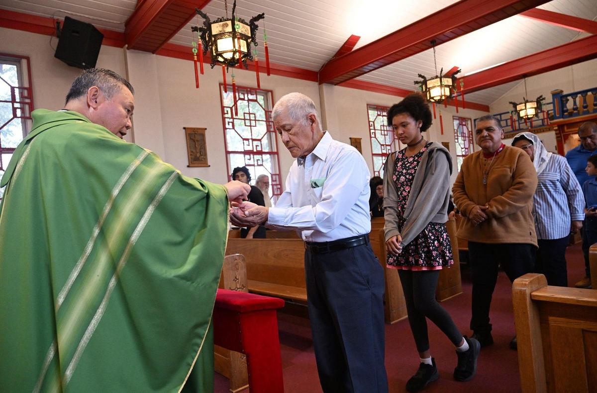 Reverend Victor Dinh, left, leads Mass at St. Genevieve Catholic Church in Chinatown, Sunday, Oct. 27, 2024, in Fresno.
