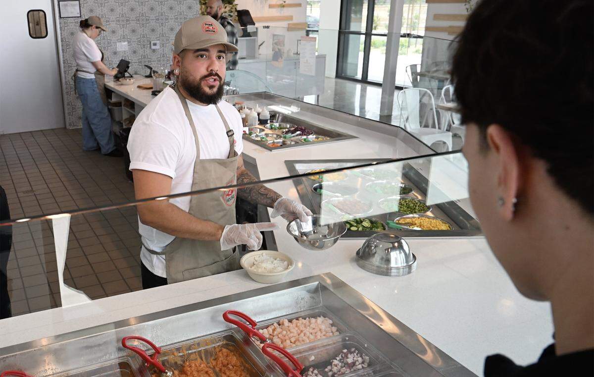 A customer has a poke bowl made to his order at the new Poke House, located at The Avenue at Heritage Grove, Wednesday, May 20, 2026 in Clovis.