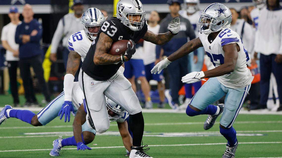 Las Vegas Raiders tight end Darren Waller picks up a first down after catching a pass as Dallas Cowboys’ Keanu Neal and Jayron Kearse move in to make the stop in the first half of an NFL game in Arlington, Texas, Sunday, Nov. 25, 2021.