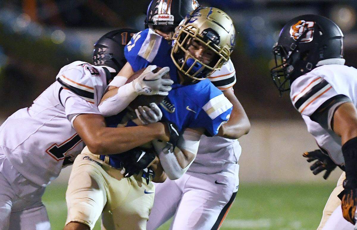 Clovis High’s Tyler Marquez, right, is tackled by Central’s Caleb Shelton, left, Thursday, Sept. 29, 2022 in Clovis.