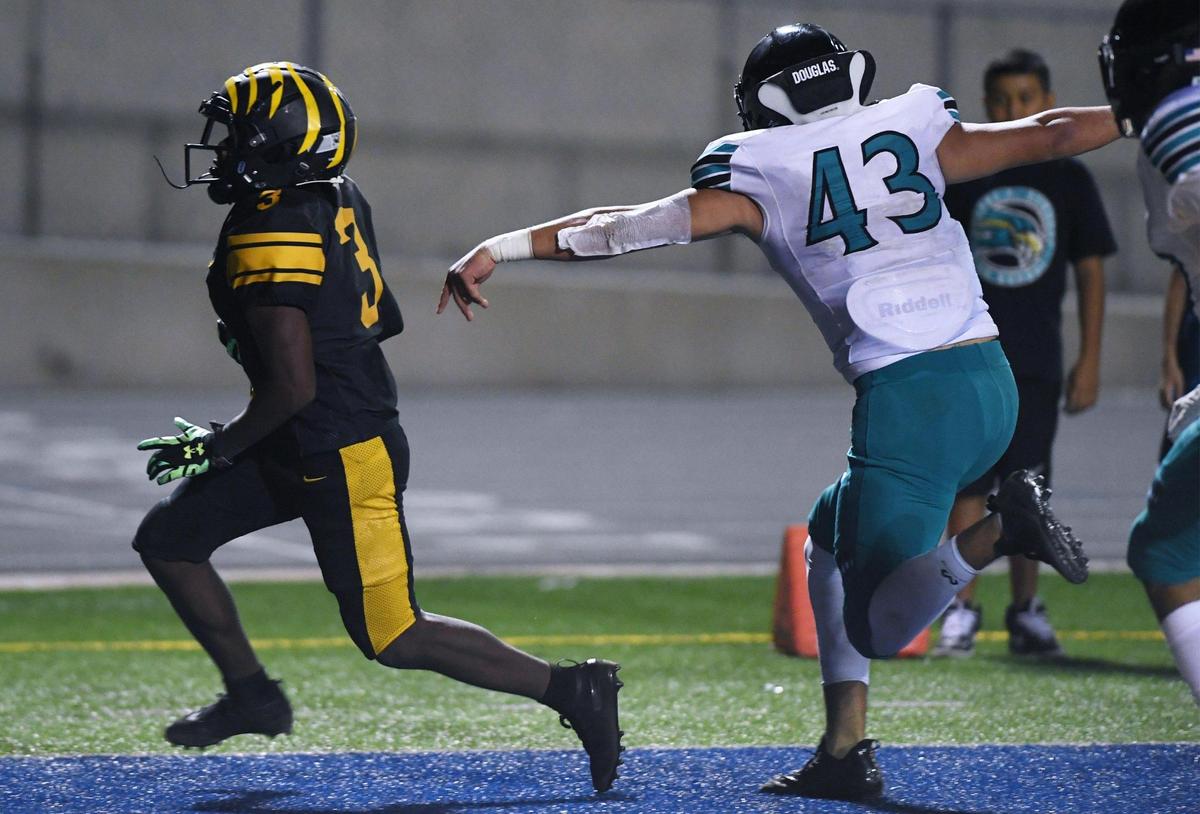 Edison’s Dezjour Malone, left, scores a touchdown with Kennedy’s Sergio Gonzalez III to the right Friday, Aug. 19, 2022 in Fresno. Edison won 20-13.