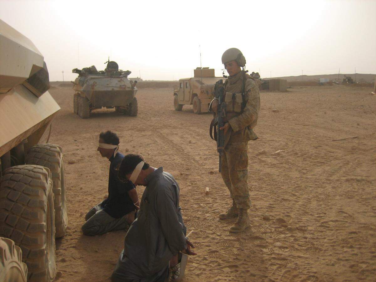 Lance Cpl. Nick Ramey guards two detainees his Marine unit captured in Iraq. The men were suspected of being foreign fighters.