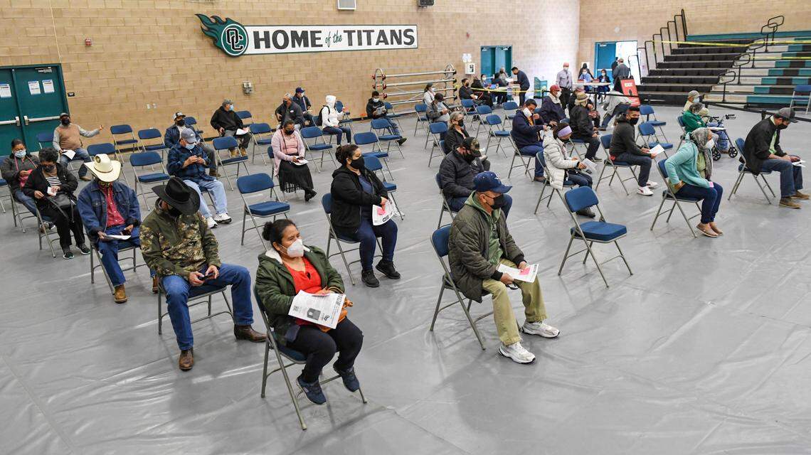 COVID-19 vaccination recipients wait in the observation area following their shots during a Fresno County rural vaccine clinic at Orange Cove High School on Tuesday, March 16, 2021.