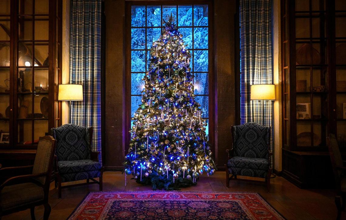 A decorated Christmas tree stands in a window inside the warm Winter Club Room of the Ahwahnee Hotel in Yosemite Valley on Wednesday, Dec. 15, 2021, following a snowstorm the day before.