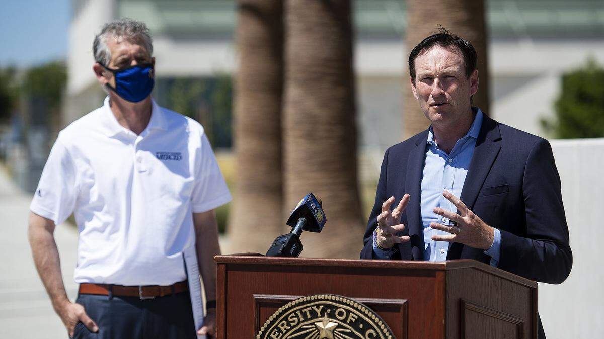 Josh Fryday, chief service officer for California Volunteers, right, speaks during a news conference to discuss the #CaliforniansForAll College Program, as UC Merced Vice Chancellor of Student Affairs Charles Nies, left, looks on at the UC Merced campus on Thursday, May 27, 2021.