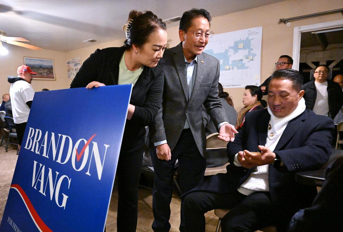 May Lee, left, stands alongside her husband Fresno City Council District 5 candidate Brandon Vang, center, as he and supporters gather waiting for the results of the special runoff election Tuesday night, March 18, 2025 in Fresno.