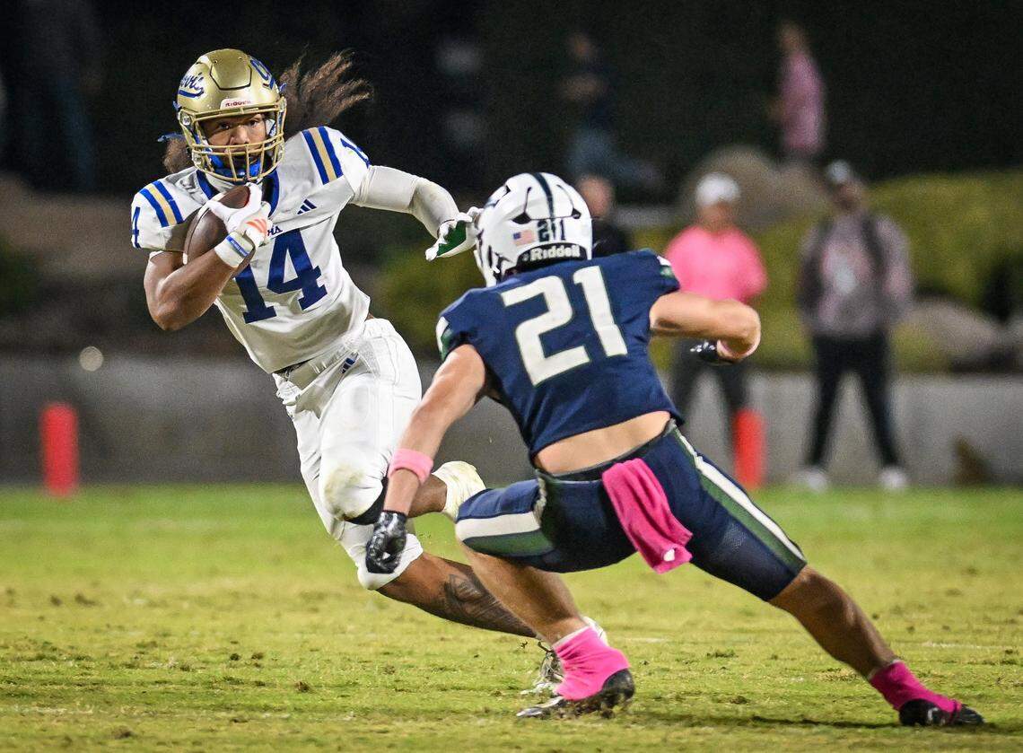 Clovis' Israel Briggs, left, puts a move on Clovis East's Tristan Kircher on a run during their game at Lamonica Stadium in Clovis on Friday, Oct. 17, 2025.