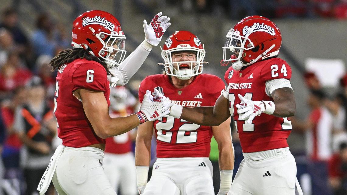 Fresno State’s Levelle Bailey, from left, and Steven Comstock congratulate Chrishawn Gordon after sacking Nevada quarterback Brendon Lewis for a loss in the first quarter of their game at Valley Children’s Stadium on Saturday, Sept. 30, 2023.