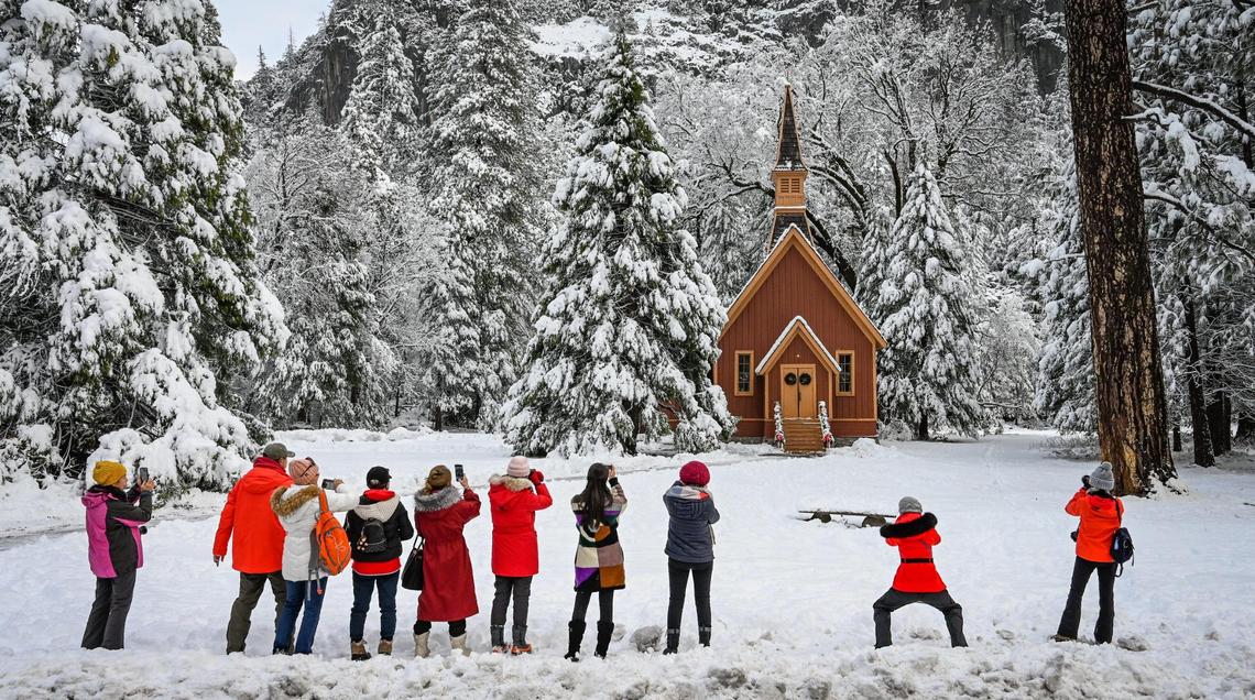 Photographers line up to photograph the snow-covered chapel in Yosemite Valley on Wednesday, Dec. 15, 2021, following a snowstorm the day before.