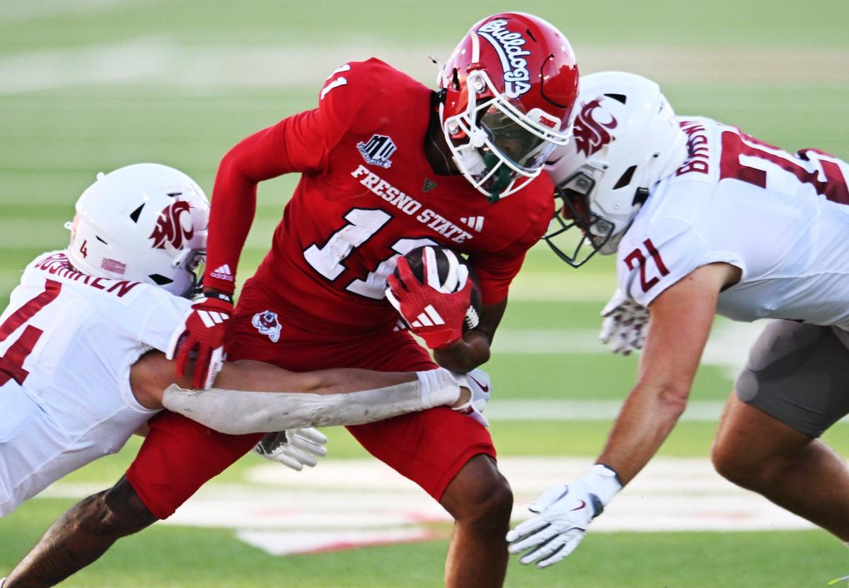 Fresno State’s Raylen Sharpe, center, is tackled by Washington State’s Kapena Gushiken, left, and Keith Brown, right, Saturday, Oct. 12, 2024 in Fresno.