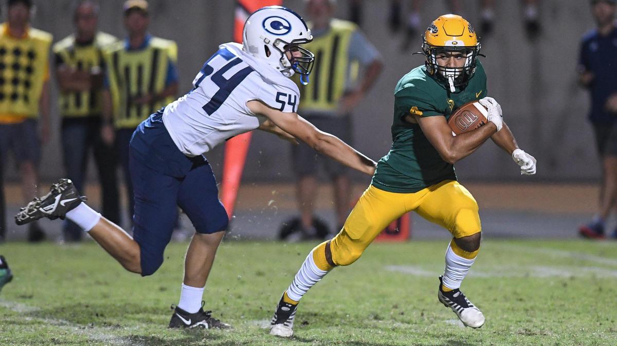 Kingsburg’s Caleb Irigoyen evades a tackle from Central Valley Christian’s Case Anker on a kickoff during their game at Kingsburg on Friday, Oct. 14, 2022.