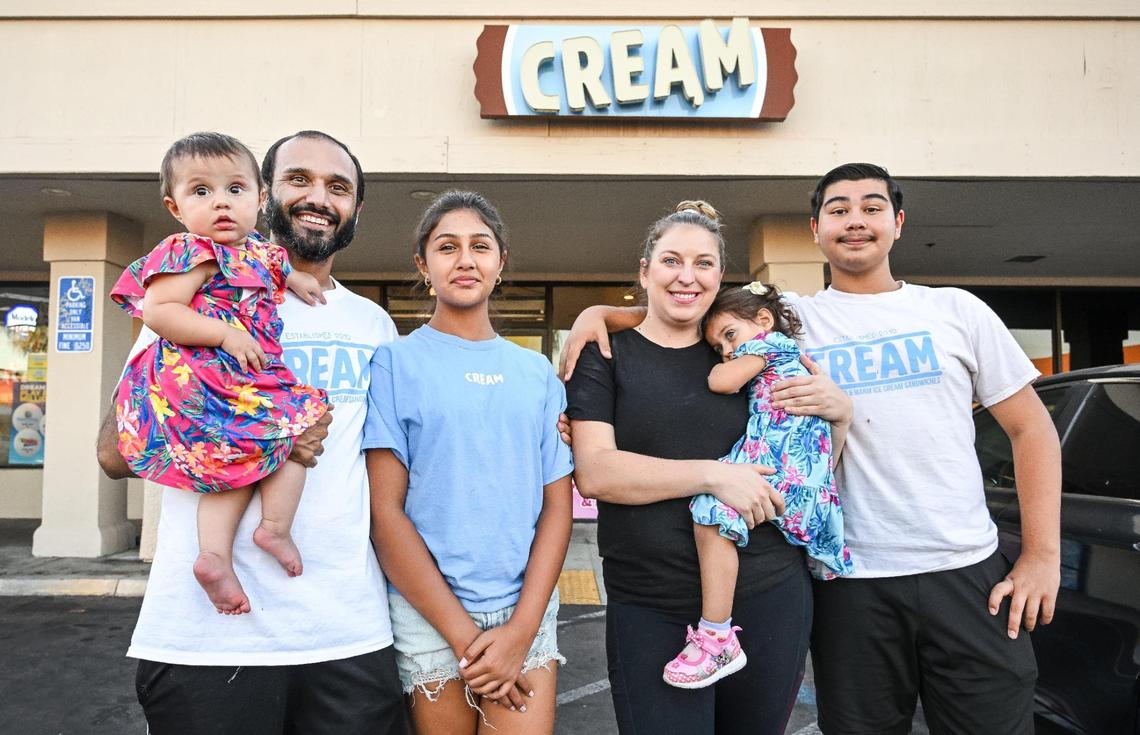 Gurvinder Sandhu and Amanda Vogel pose with their kids, from left, Madilyn “Madi” Sandhu, 9 months; Jazmyn Sandhu, 12; Evelyn Sandhu, 2; and Rohaan Sandhu, 15, outside the CREAM ice cream business they recently purchased and are running instead of their Twisted Masala food truck.