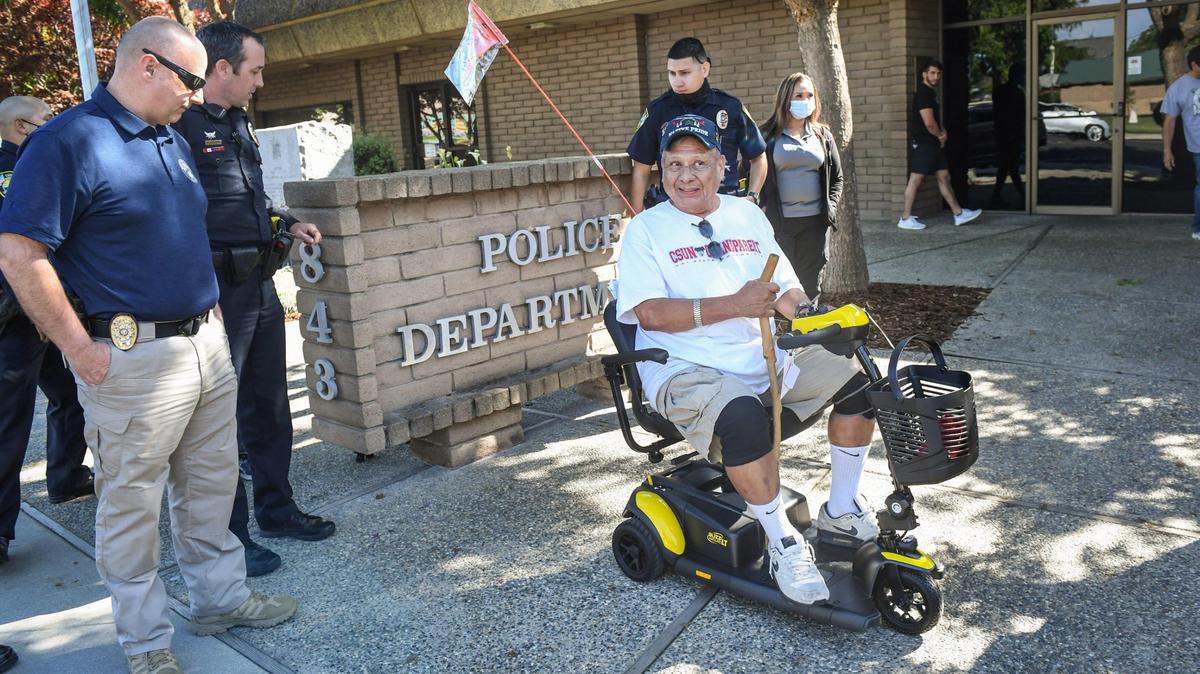 Disabled Vietnam veteran Gordon Wilson, center, of Reedley, smiles after receiving a new electric scooter presented by the Reedley Police Officer’s Association in front of the Reedley Police Department in 2021.