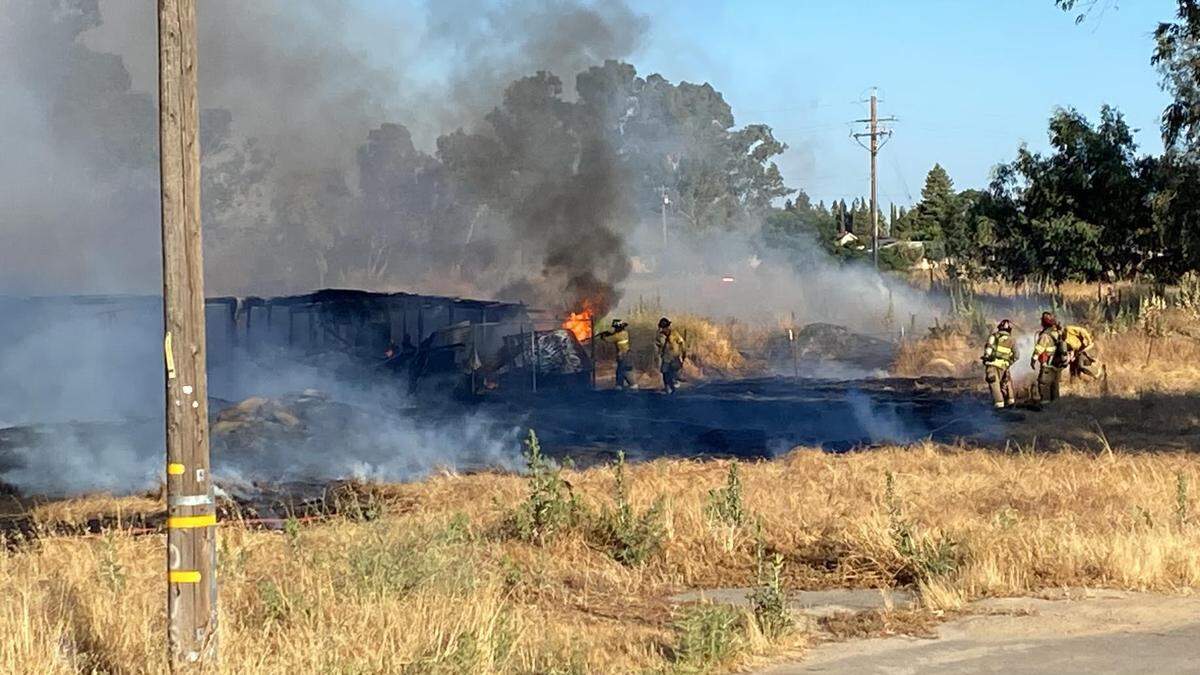 Fresno firefighters move in to keep a grass fire from moving toward homes in northwest Fresno.