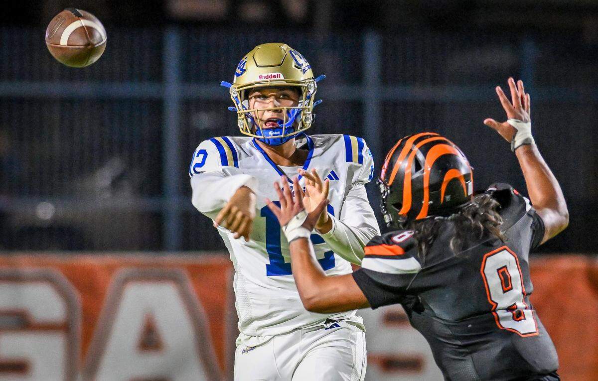 Clovis quarterback Deagan Rose gets pressure from Central East's Juan Ochoa while attempting a pass in their game at Koligian Stadium in Fresno on Friday, Oct. 24, 2025.