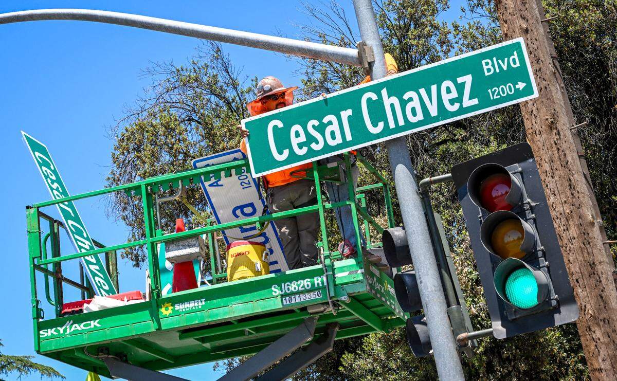 A work crew installs a new Cesar Chavez Boulevard sign in place of a Ventura Avenue sign at C Street in Fresno on Friday, June 14, 2024. Cesar Chavez Boulevard will now be the name of the road starting from California and Marks in west Fresno, continuing east along Ventura through downtown and then down Kings Canyon Road ending at Peach Avenue for a total of 10 miles. 