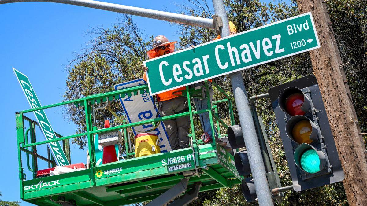 A work crew installs a new Cesar Chavez Boulevard sign in place of a Ventura Avenue sign at C Street in Fresno on Friday, June 14, 2024. Cesar Chavez Boulevard will now be the name of the road starting from California and Marks in west Fresno, continuing east along Ventura through downtown and then down Kings Canyon Road ending at Peach Avenue for a total of 10 miles.