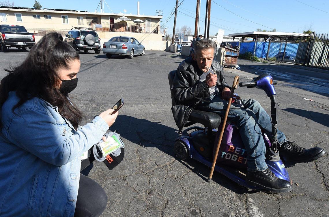Volunteer Ashley Morris talks with homeless Fresno native Michael Fowler, 66, during a Point in Time count survey for the Fresno Madera Continuum of Care in a homeless encampment in the Tower District, Feb. 25, 2022.