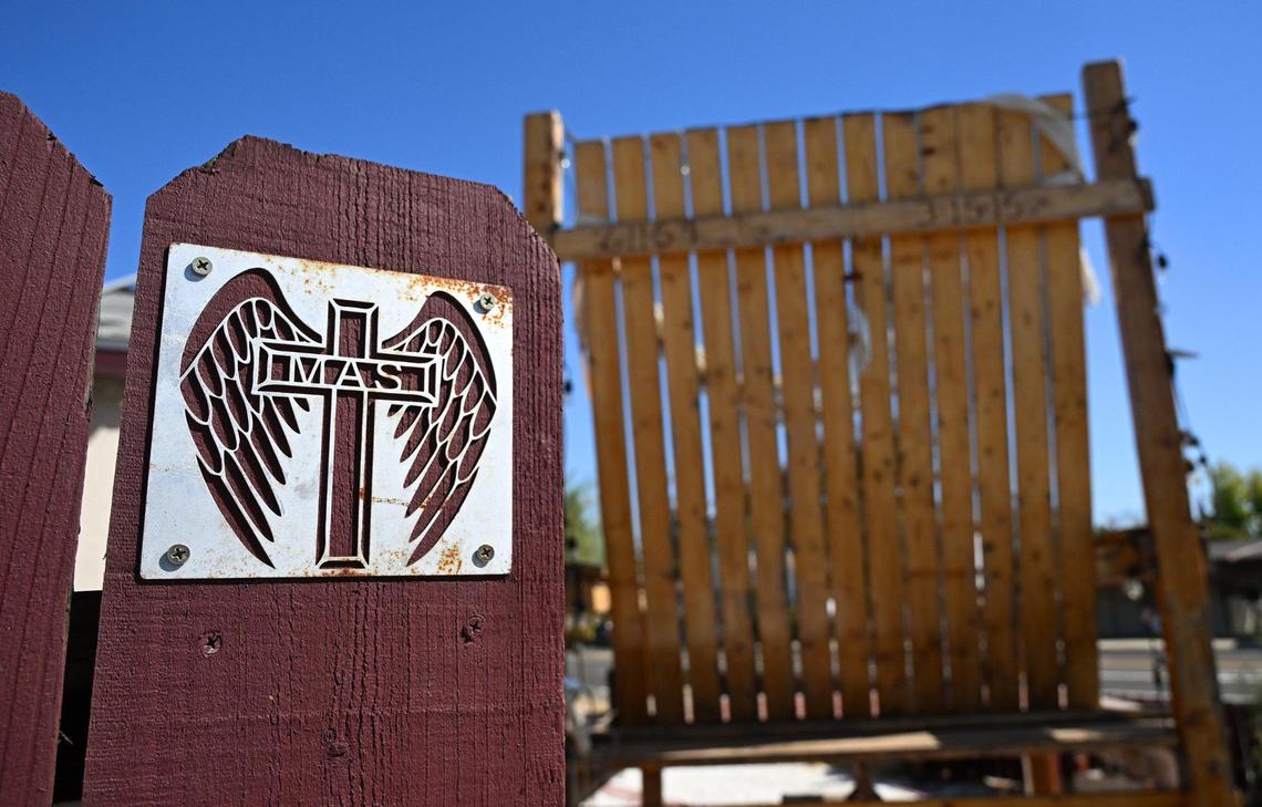 A plate featuring his wife’s initial with angel wings is seen on the fence near the large wooden chair Robert Sandoval constructed to memorialize his wife Mary Ann who died in a car crash in 2015. Photographed Sept. 26, 2024 in Fresno
