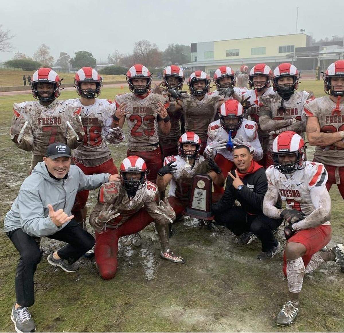 The Fresno City College defensive backs poses with the Northern California Bowl trophy.