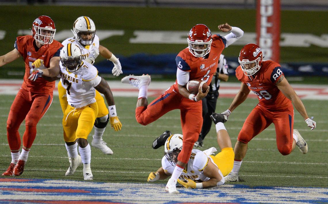 Fresno State quarterback Marcus McMaryion, center, dances past a tackle attempt by Wyoming’s Logan Wilson on a 26-yard run in the Bulldogs’ 27-3 victory over the Cowboys at Bulldog Stadium in Fresno on Saturday, Oct. 13, 2018. McMaryion accounted for four touchdowns in the victory, two passing and two rushing.