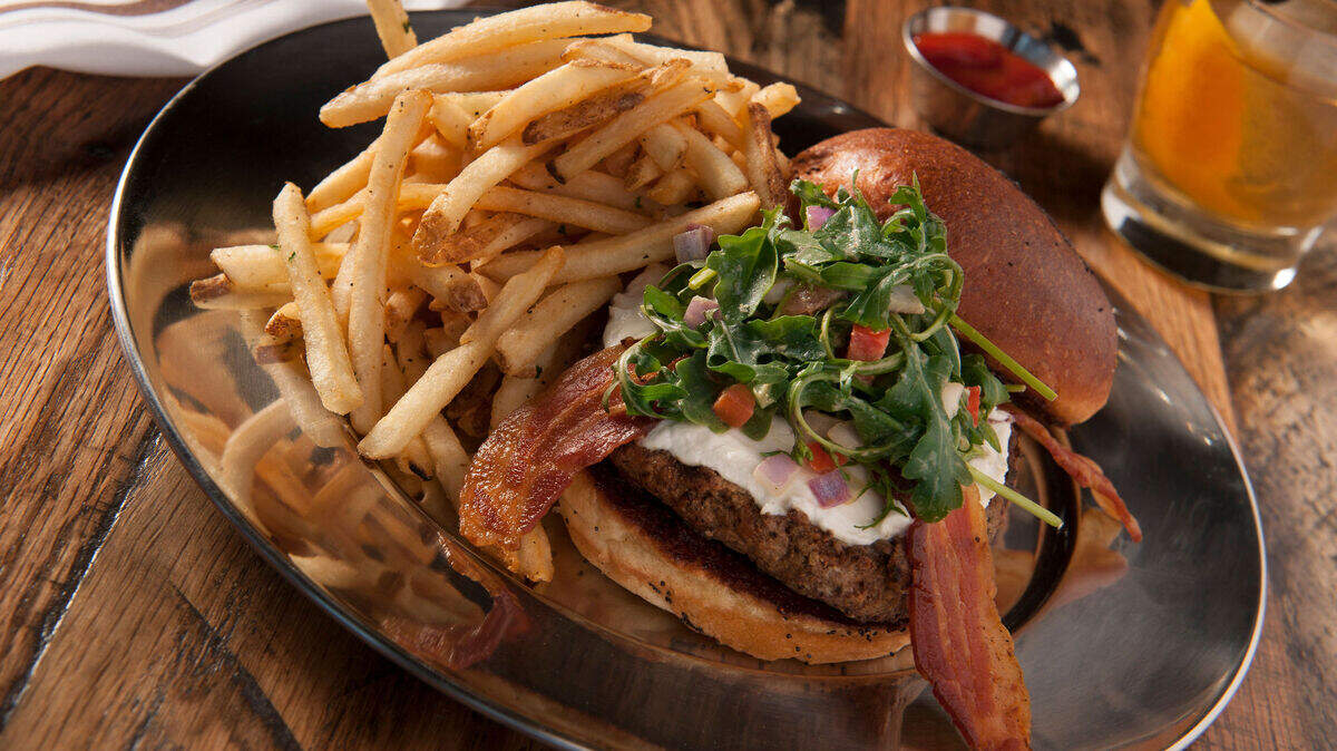 The Fresno Fig Burger is a signature entree available at all Eureka! restaurants. It features an Angus beef patty, bacon, fig marmalade, goat cheese, arugula and a spicy porter mustard.