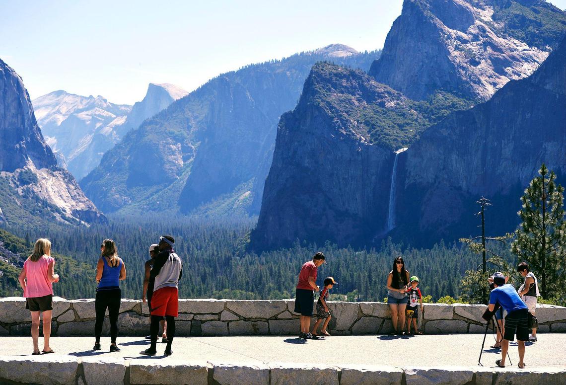 Visitors take photographs at Tunnel View overlooking Yosemite Valley as Yosemite National Park re-opens after a historic closure Thursday, June 11, 2020.