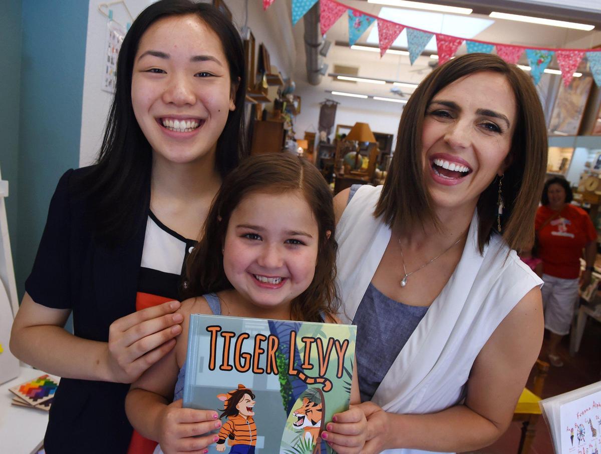 Livy Garcia, 7, center, laughs with her aunt Erin Garcia, right, and Clovis North student Ivreese Tong, 16, left, at Vivily Vintage & Handmade Friday, June 28, 2019 in Fresno. Erin Garcia co-authored Tiger Livy, an inspirational book illustrated by Tong, based on Livy Garcia’s struggle with juvenile dermatomyositis.