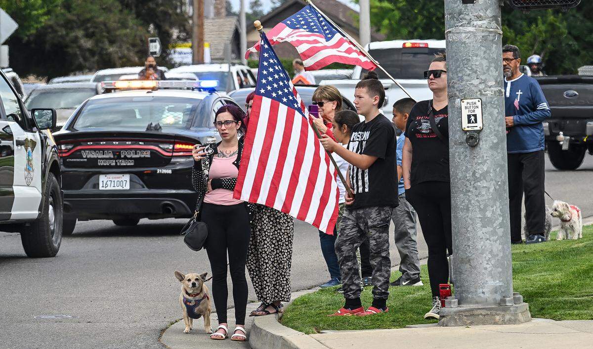 Residents gather along Caldwell Avenue in Visalia as a procession of law enforcement vehicles escorts the body of Fallen TCSO Deputy Randy Hoppert from the Tulare County Coroner’s Office in Tulare to Salsar and Dillard Funeral Home in Visalia on Monday, April 13, 2026. 