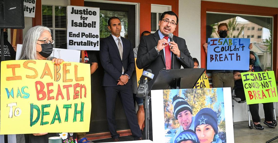 Attorney Edgar Flores of the Gonzalez and Flores law firm of Nevada is surrounded by supporters of Isabel De La Torre while holding a news conference to announce a lawsuit filed against the Clovis Police Department in the death of De La Torre earlier this year, outside the law office of attorney Kevin Little in Fresno on Friday, June 17, 2022.