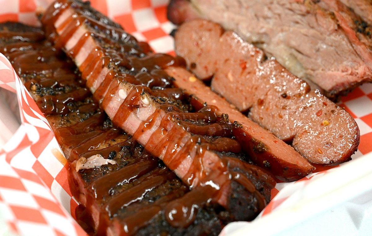 Smoked ribs drizzled with homemade BBQ sauce, along with a hotlink and tri tip, at The Hotbox BBQ.