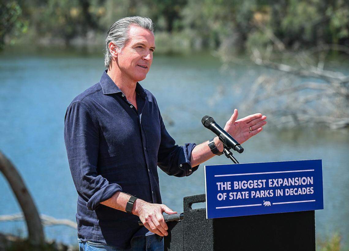 California Gov. Gavin Newsom announces the expansion of the state park system during a news conference near the Sycamore Island fishing dock along the San Joaquin River Parkway in Madera County on Wednesday, April 22, 2026.