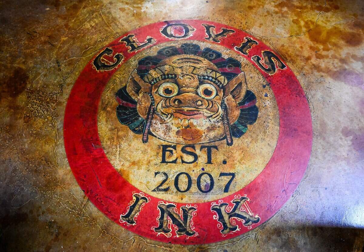 A Clovis Ink Tattoo sign is painted on the floor at the tattoo parlor on Monday, June 29, 2026. Daniel Rudolfo Acosta III, opened Clovis' first tattoo parlor with his father 19 years ago.