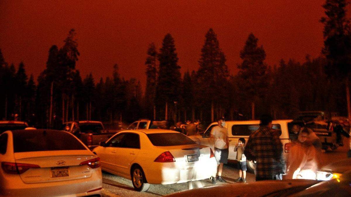 People waiting for rescue out of China Peak as the Creek Fire rages in the forest beyond.